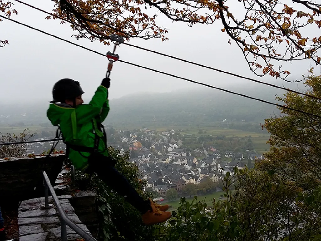 Jugendlicher in grüner Jacke startet in die Seilrutsche.